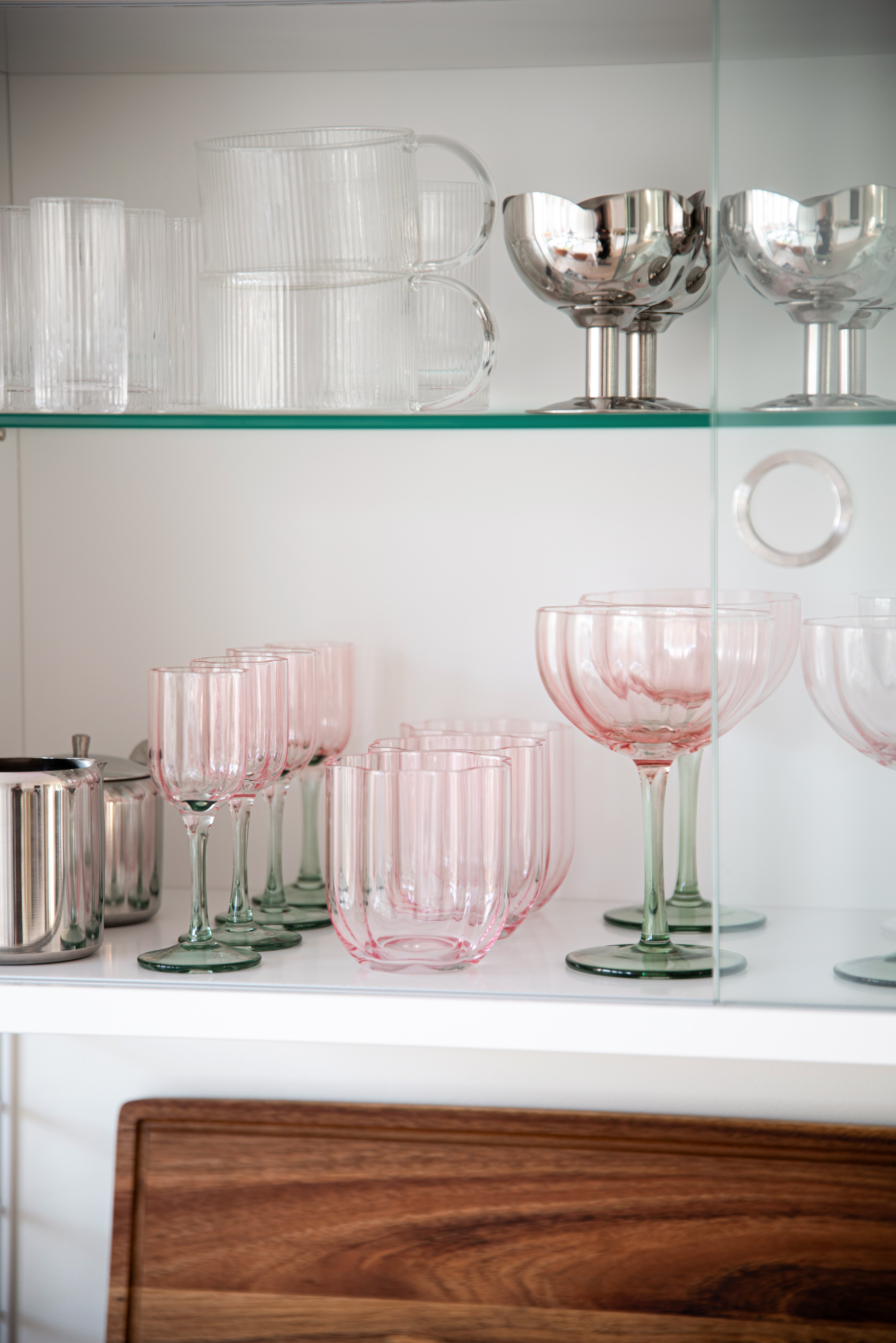 Vitrinskåp med glas och metallbägare.