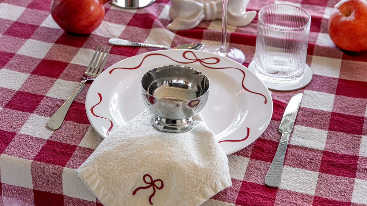 Dukat bord med juligt porslin och en liten metallskål på servett.