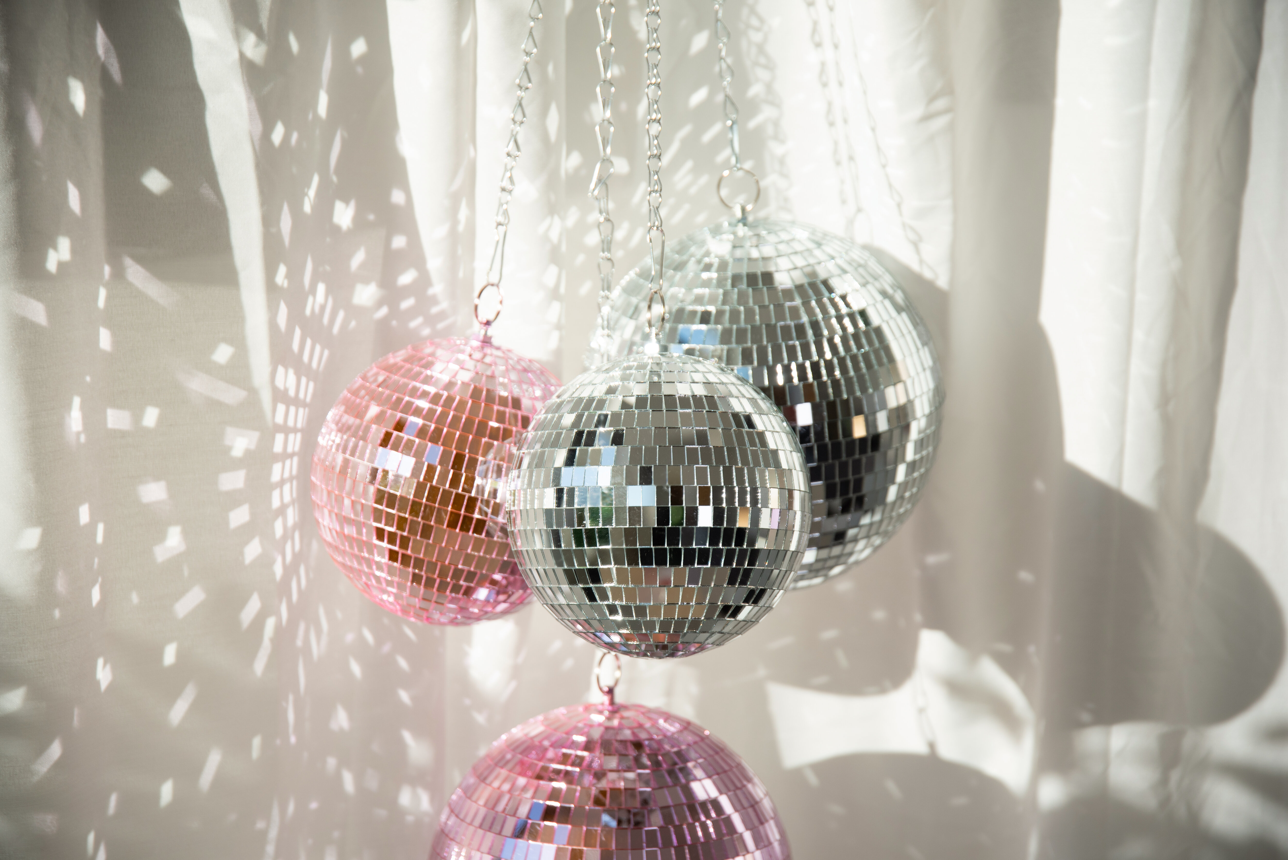 Hängande discokulor i silver och rosa.