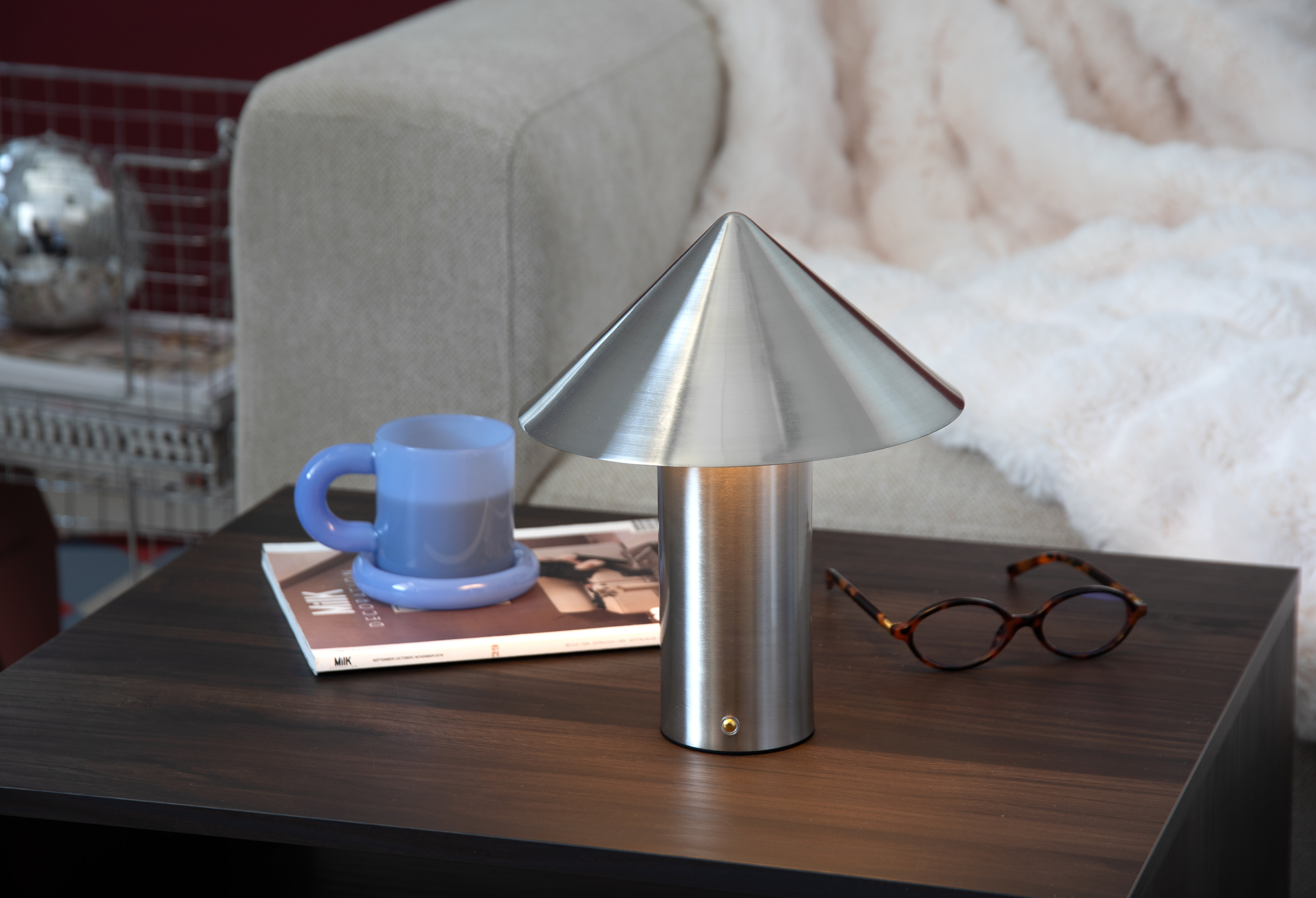 Soffgrupp med bord i mitten, kaffekoppar och en lampa