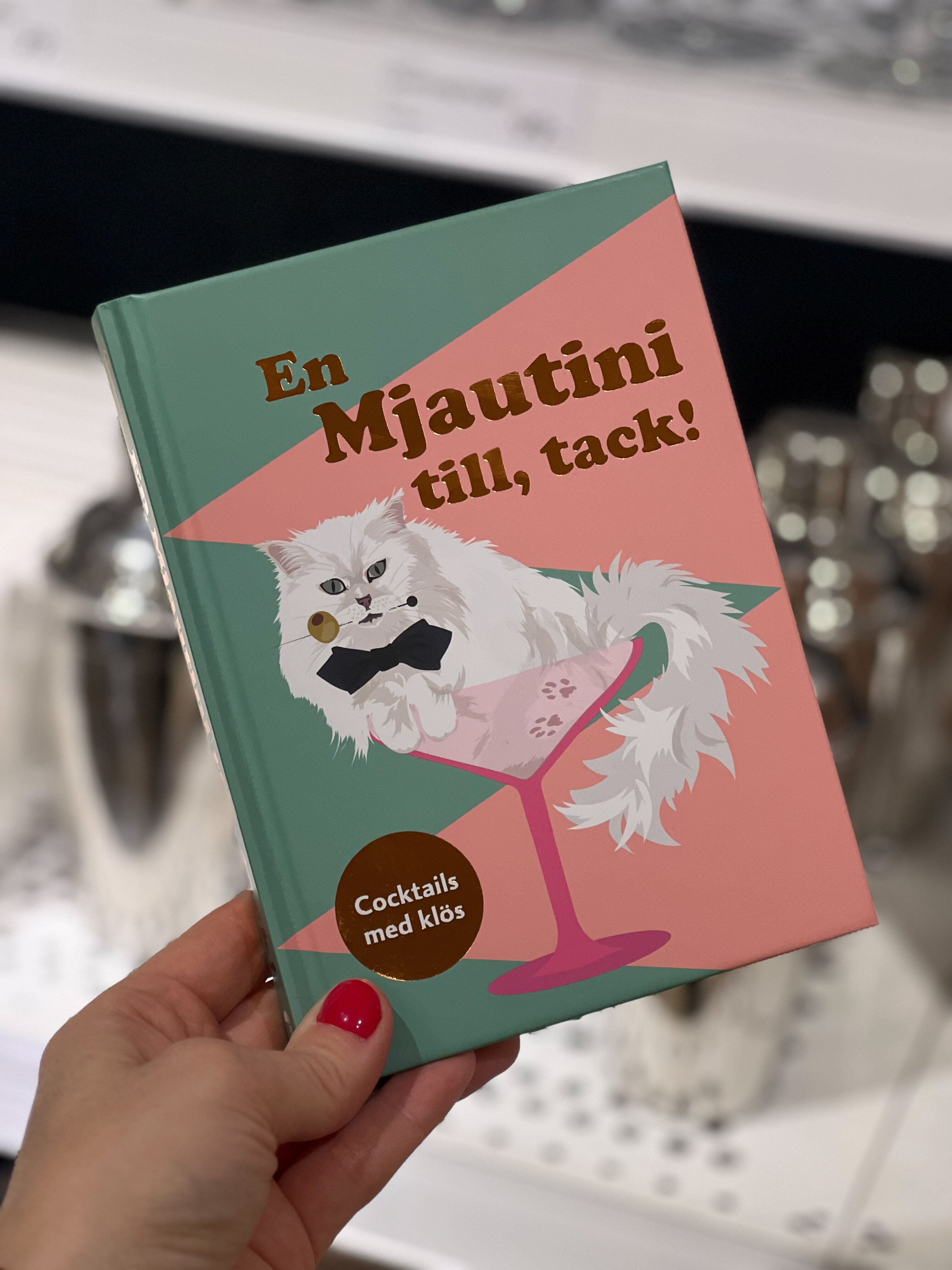 Hand som håller bok med kattmotiv.