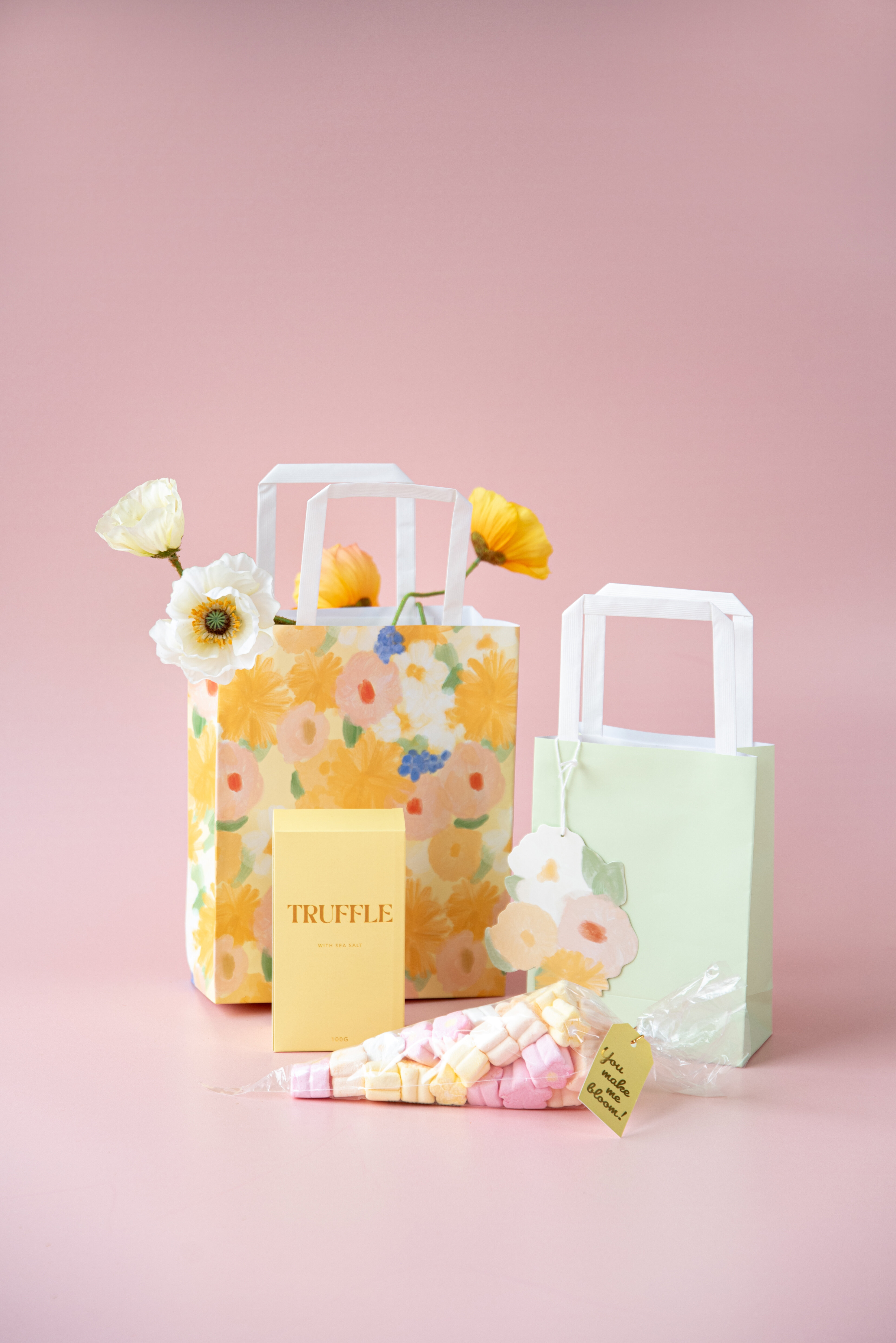 Presentkit med presentpåse med pappersblommor och godis.