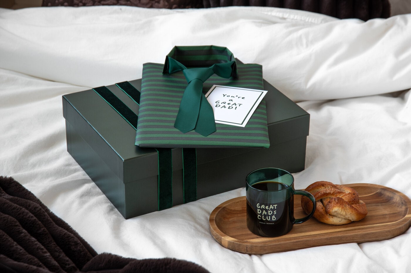 Fars dag-presenter i grönt med presentask, skjorta och slips, mugg med kaffe och bulle.