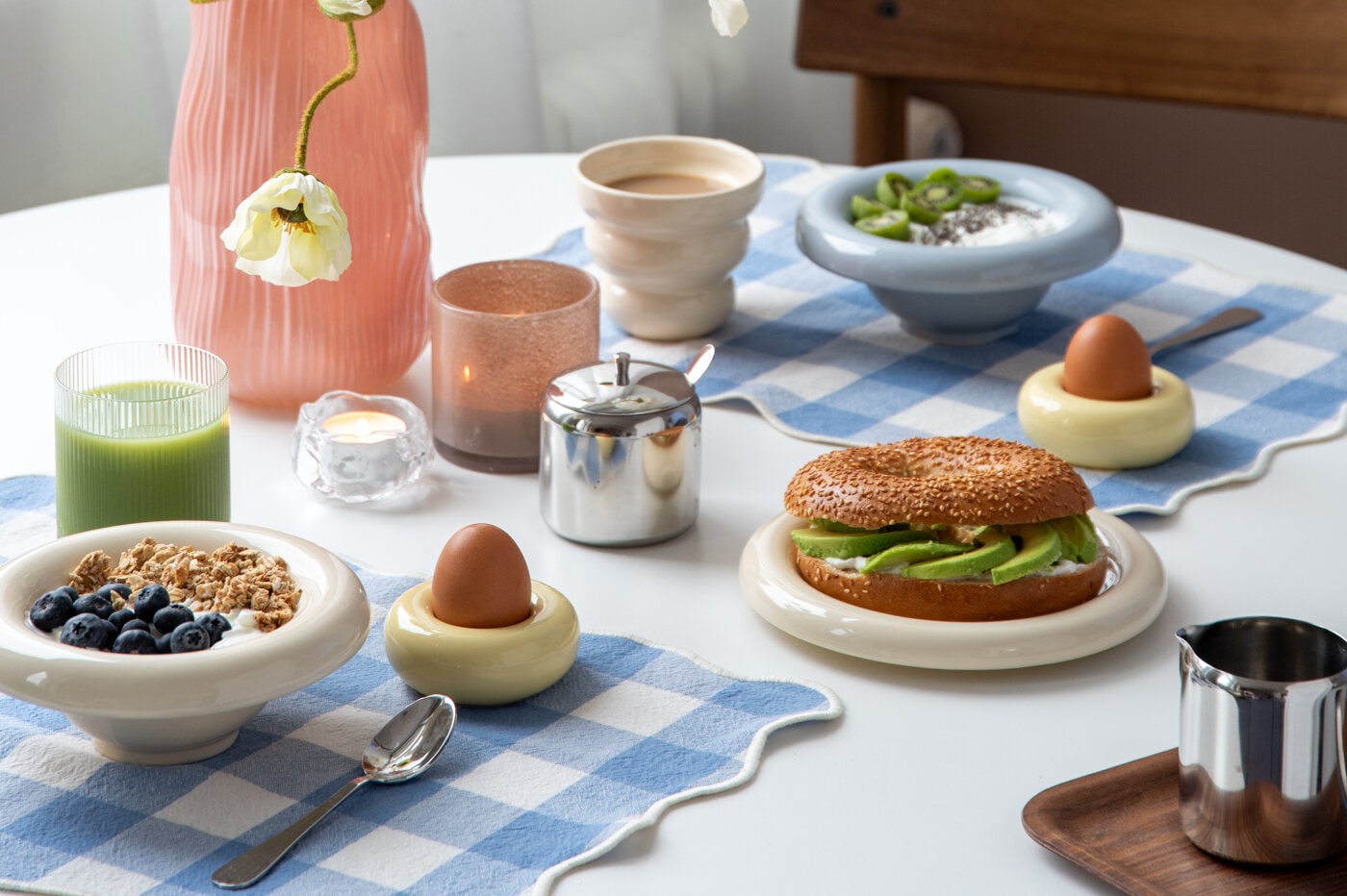 Frukost i ljusblå bullig skål, ribbat glas och på blårutig bordstablett.