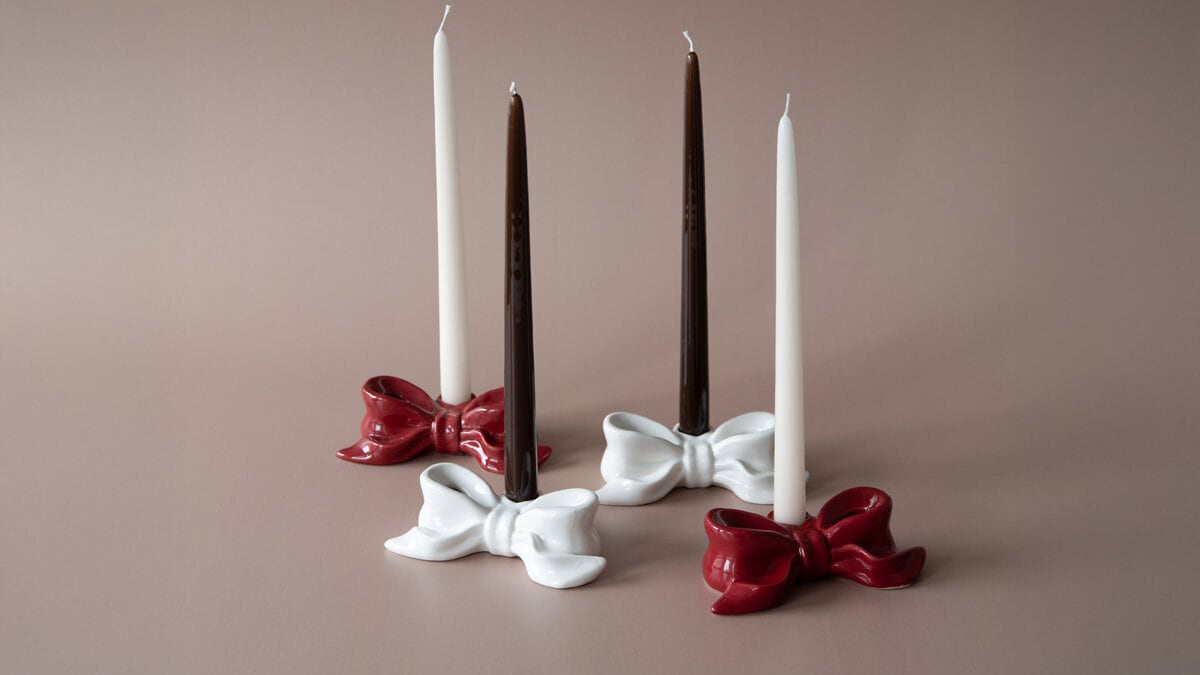 Röda och vita rosettformade ljusstakar med ljus i.