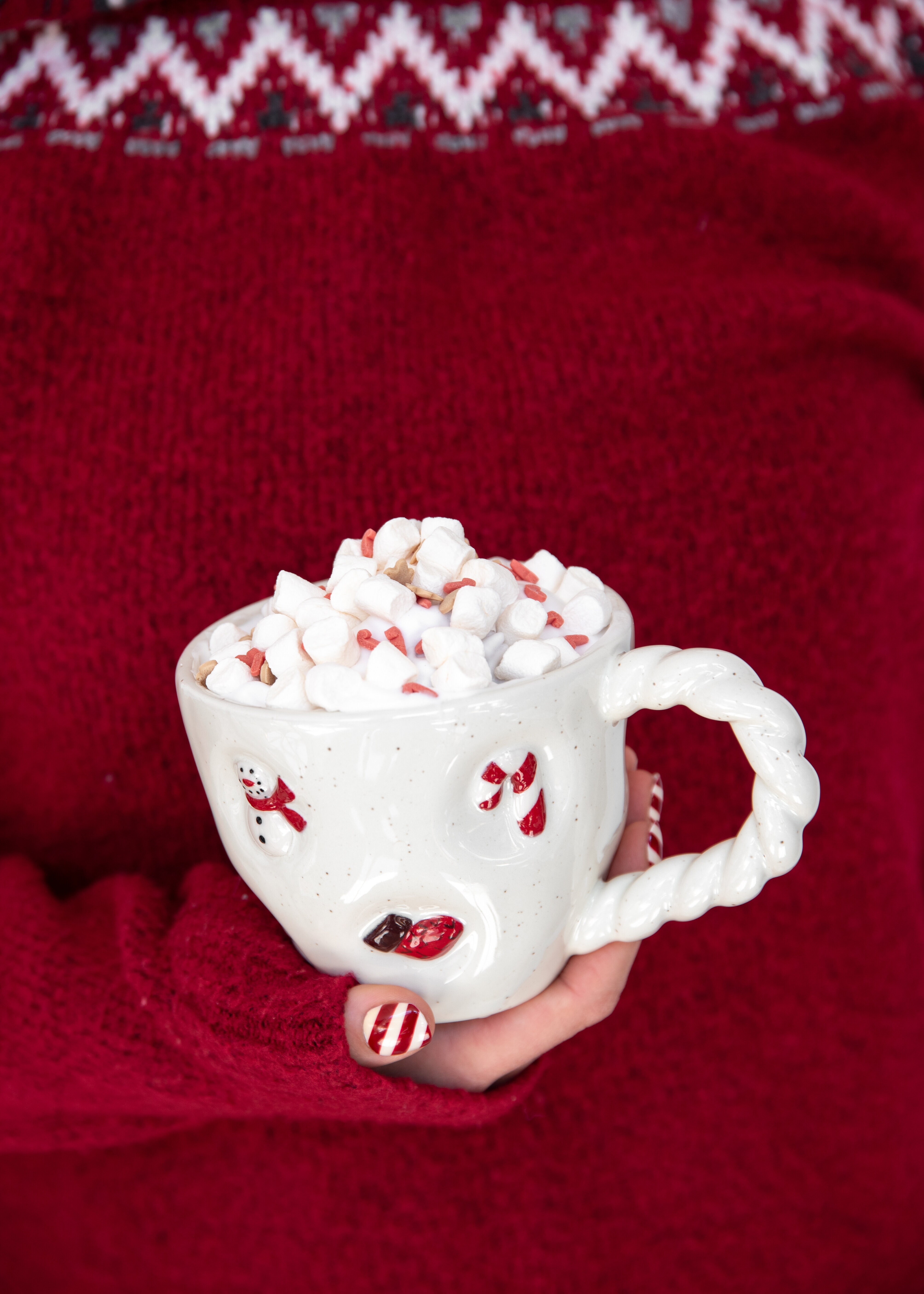 Två julmuggar med varm choklad och marshmallows.