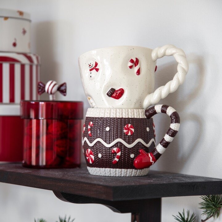 Muggar med julmotiv på en hylla i kök.