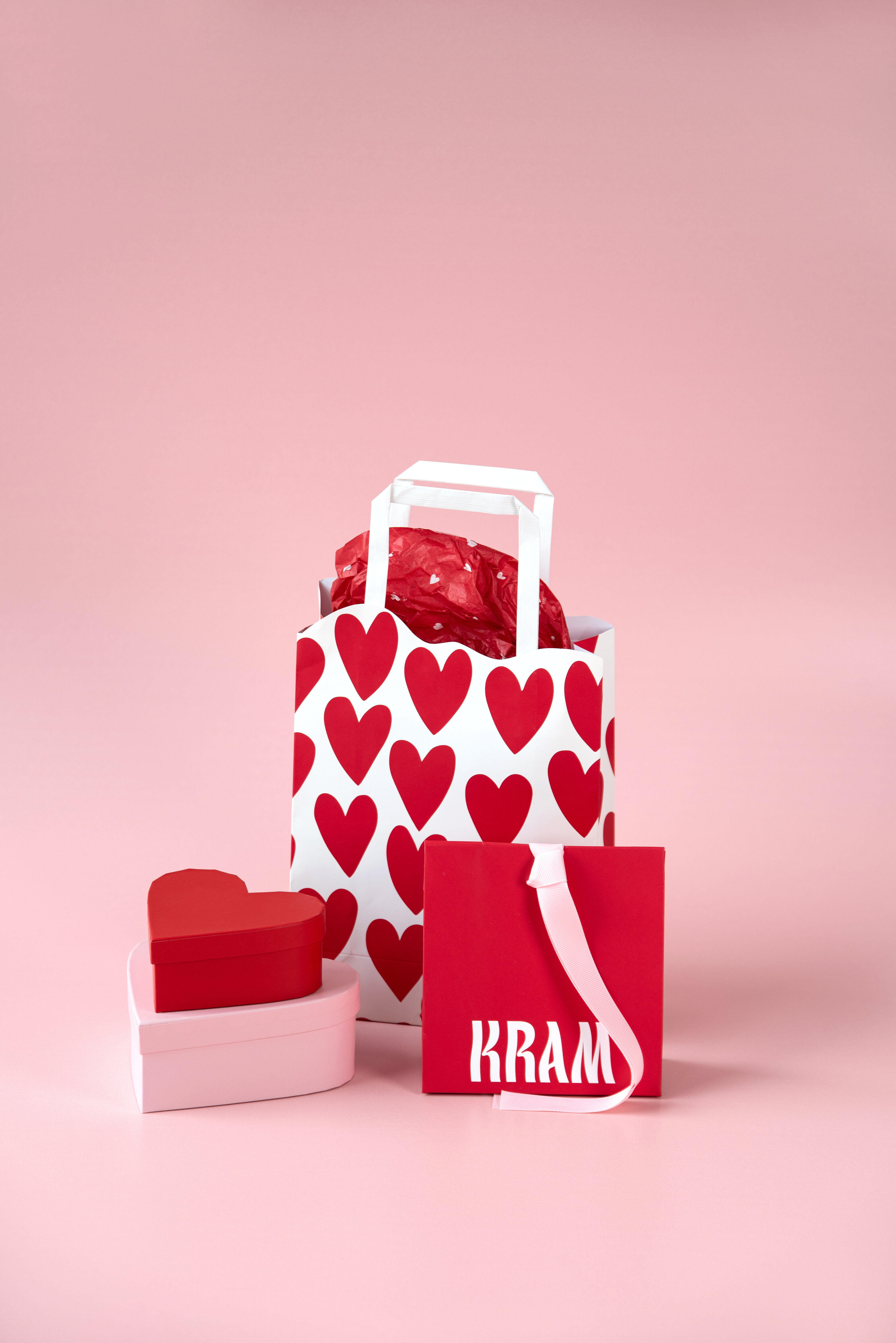 Presentpåsar och hjärtformade presentboxar i rött och rosa.