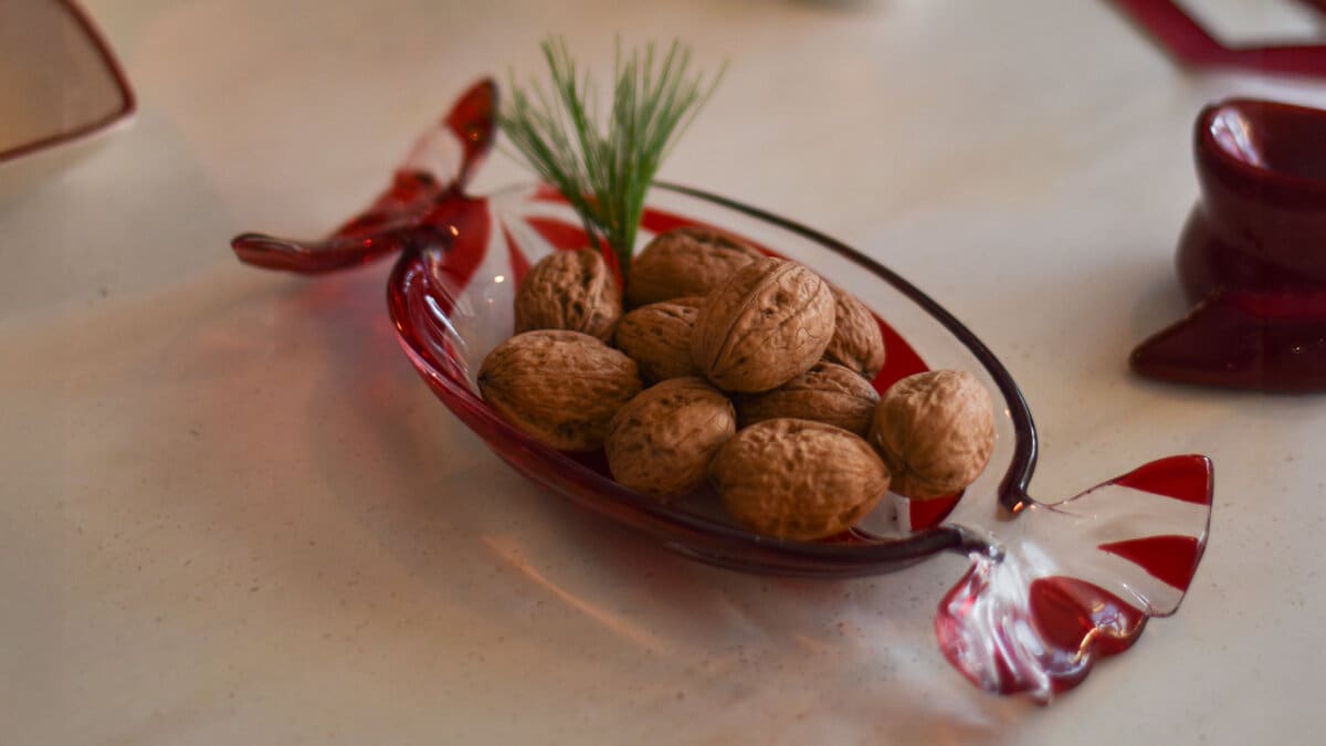 Röd glaskaramellskål fylld med nötter.