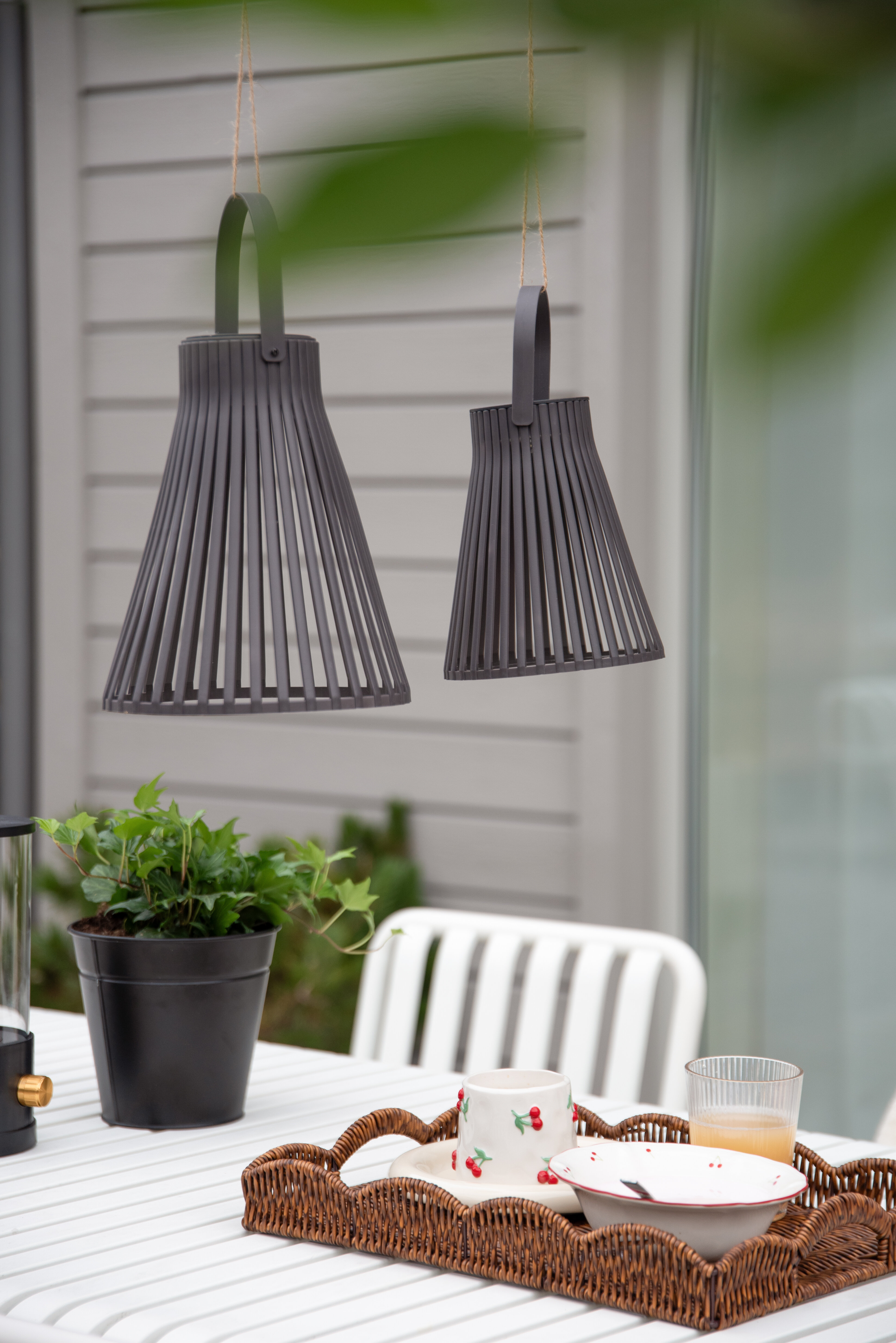 Två svarta hängande lampor i utomhusmiljö