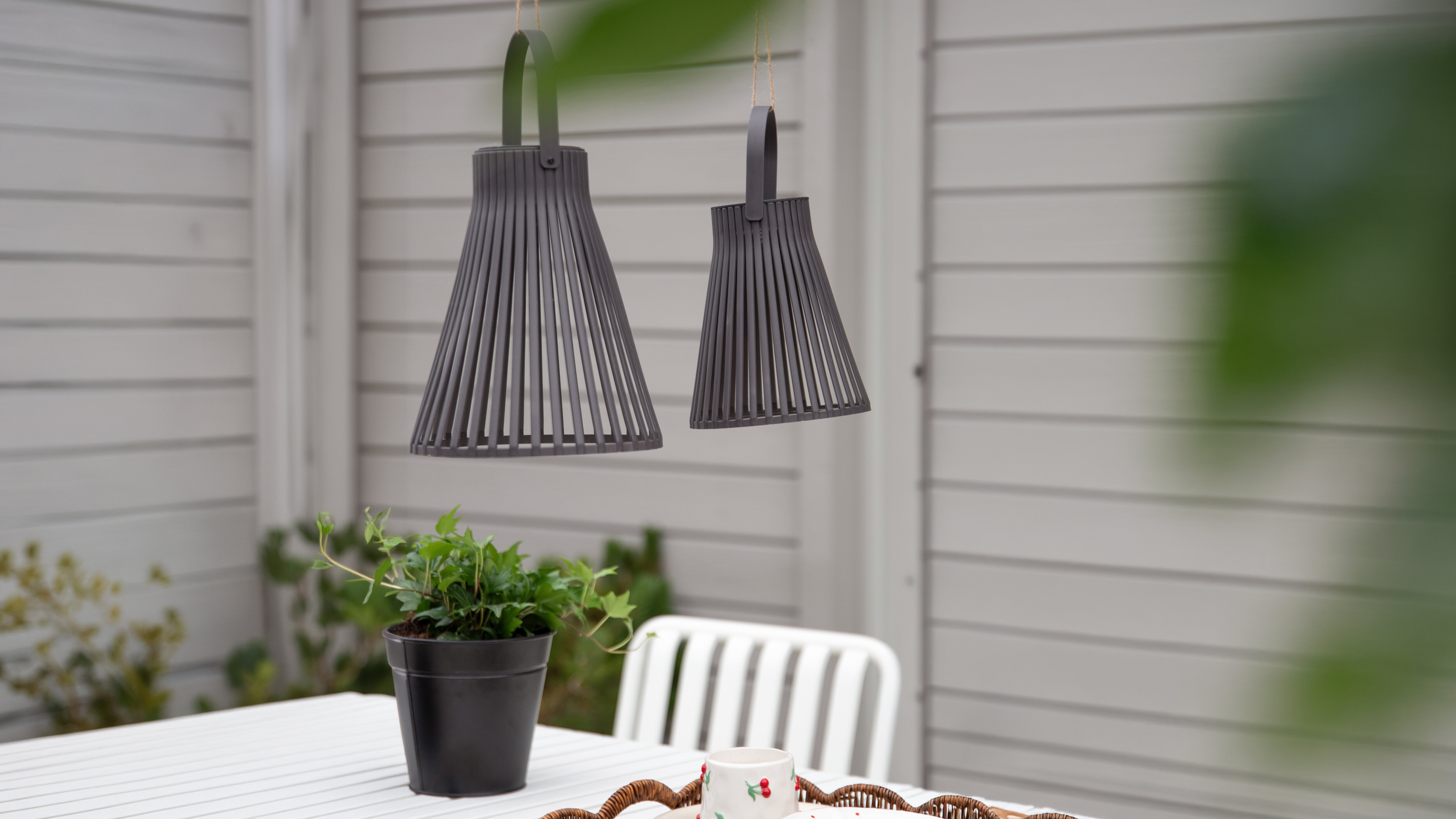 Två svarta hängande lampor i utomhusmiljö