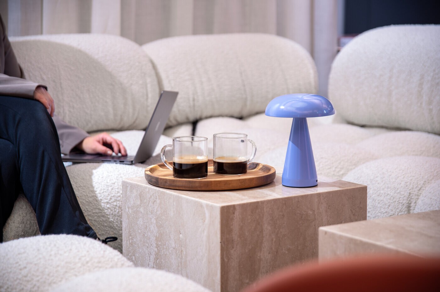 Soffgrupp med bord i mitten, kaffekoppar och en lampa