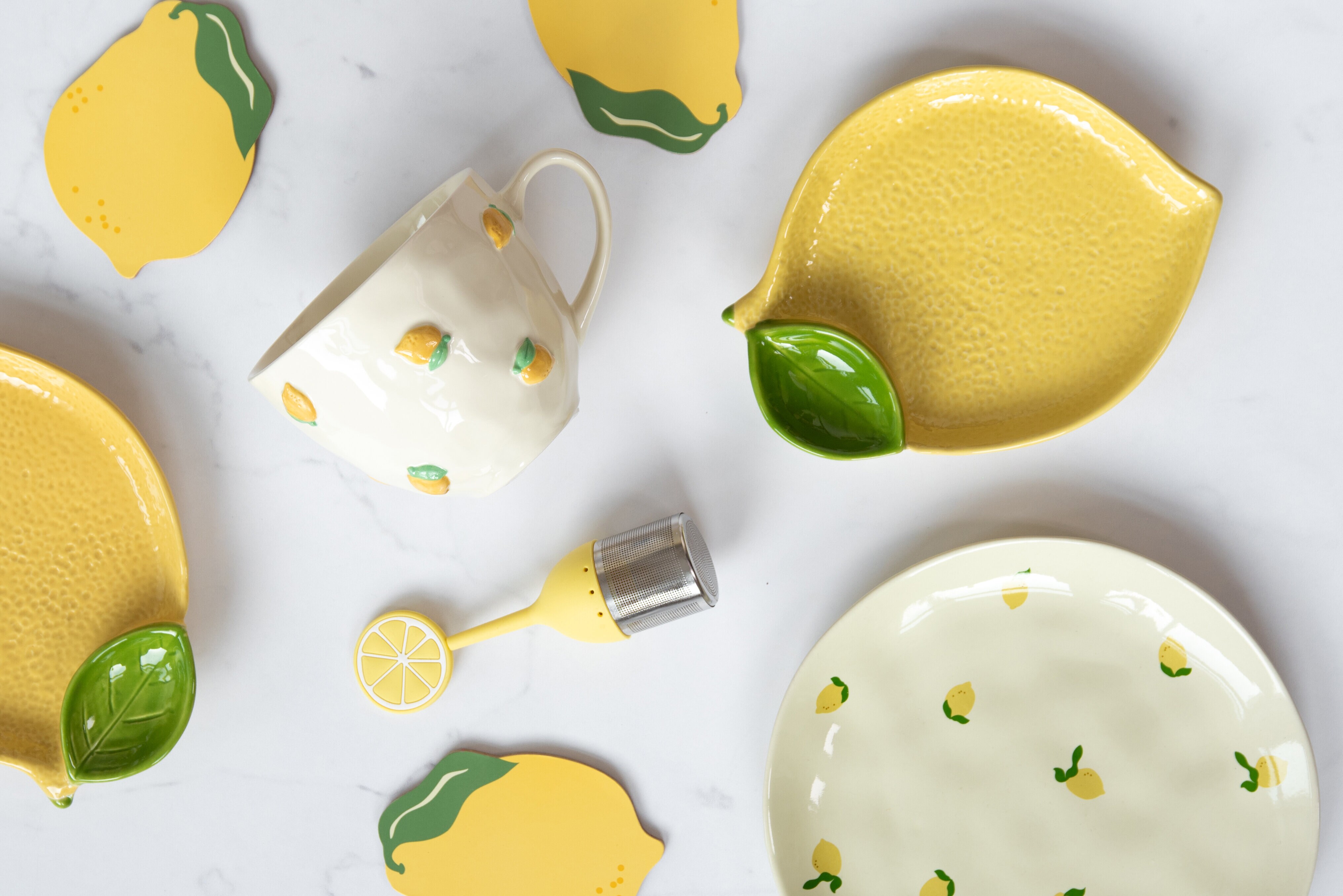 Citronformat fat, mugg med citroner och assiett med citroner på mot ljus bakgrund.