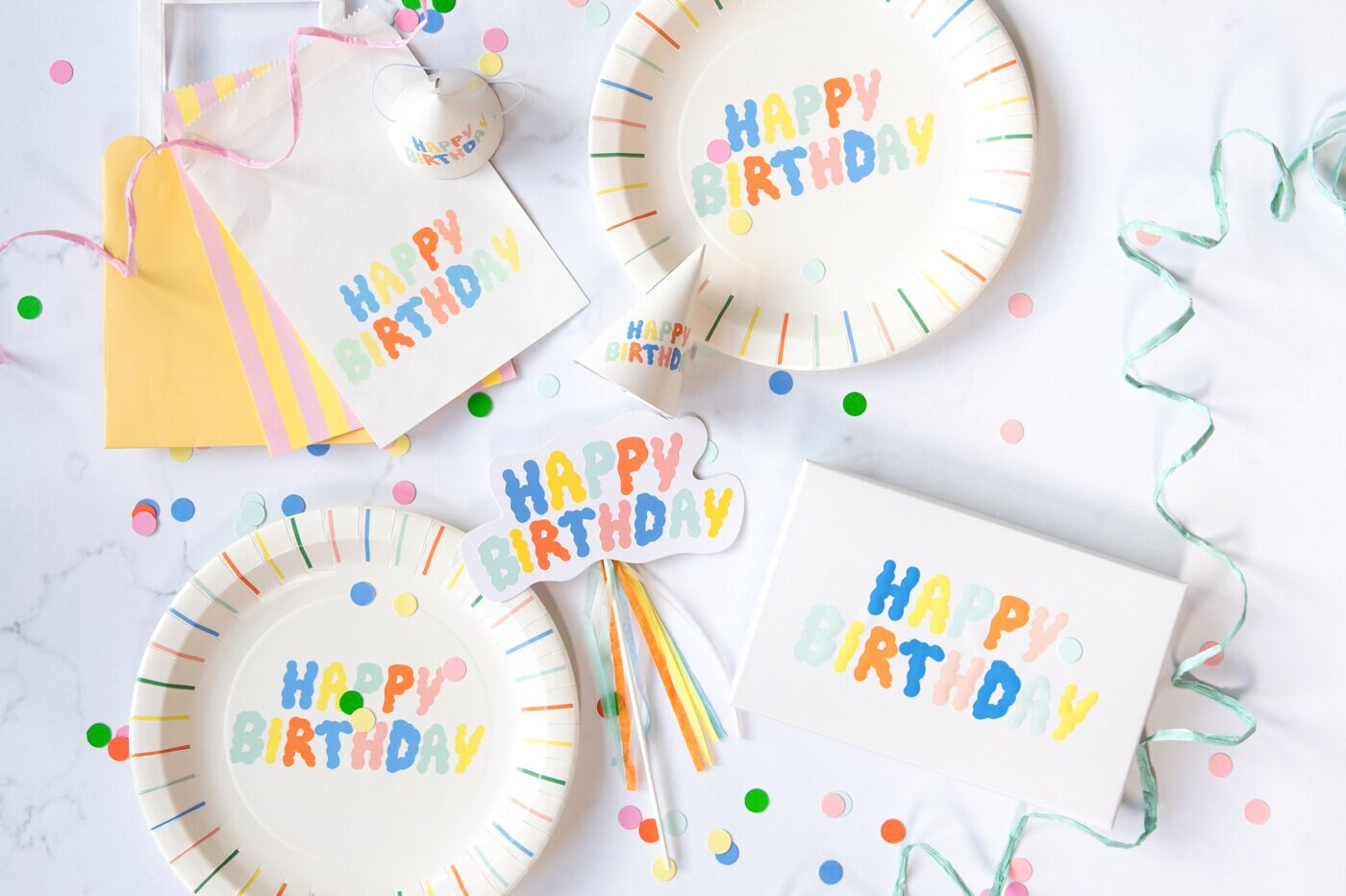 Engångsartiklar för kalas med färgglada tallrikar, servetter och dekorationer.