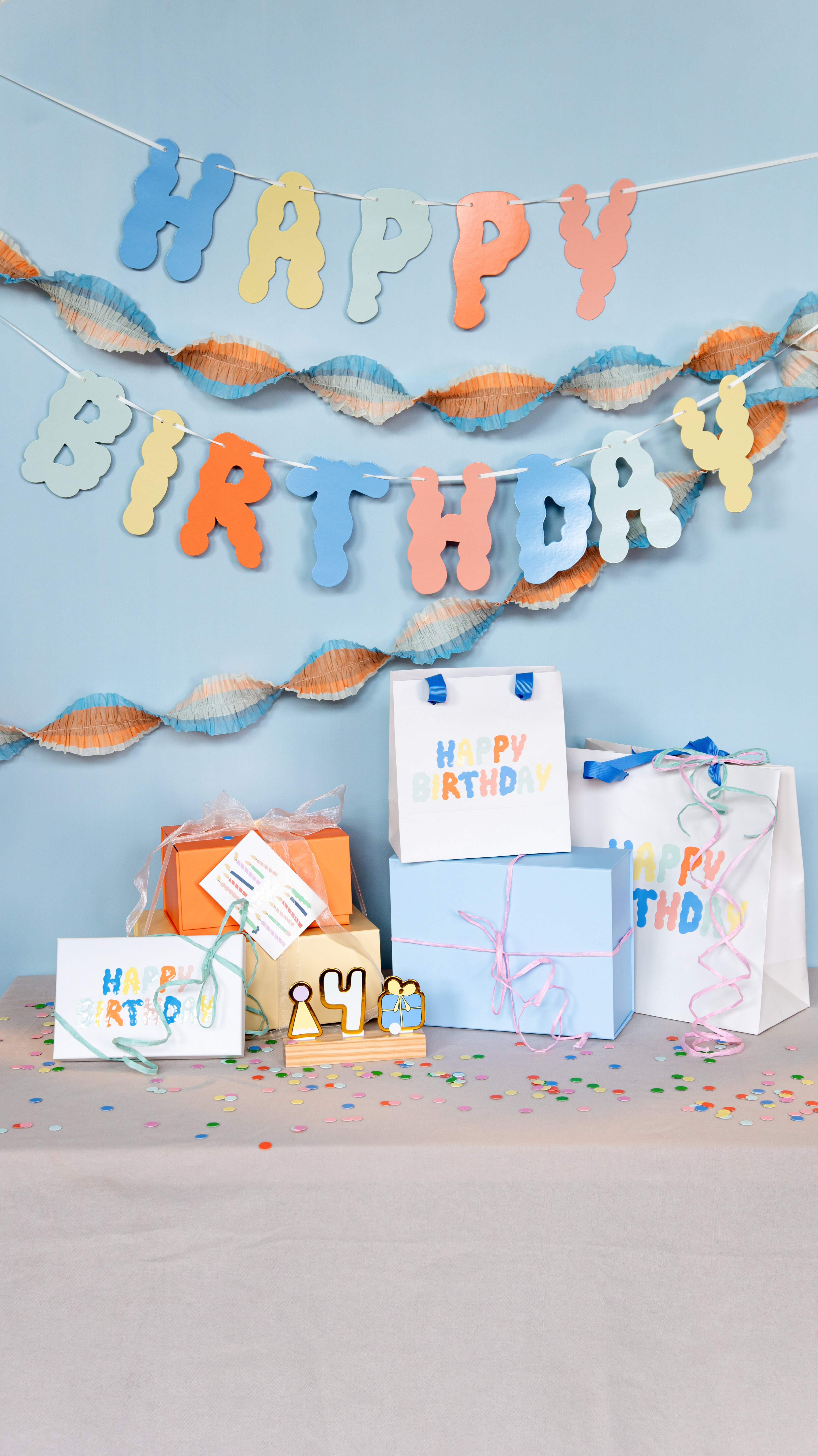 Färgglada födelsedagspresenter och presentpåsar med ”Happy Birthday”.