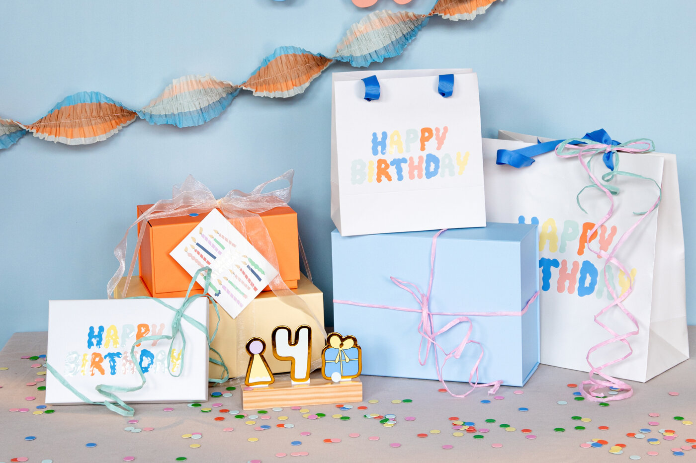 Färgglada födelsedagspresenter och presentpåsar med ”Happy Birthday”.