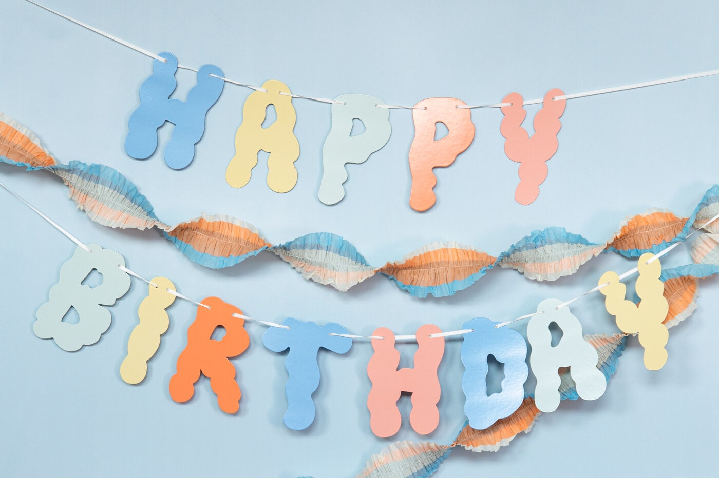 Färgglada hängande girlanger en som är snurrad och en med texten "Happy Birthday”.