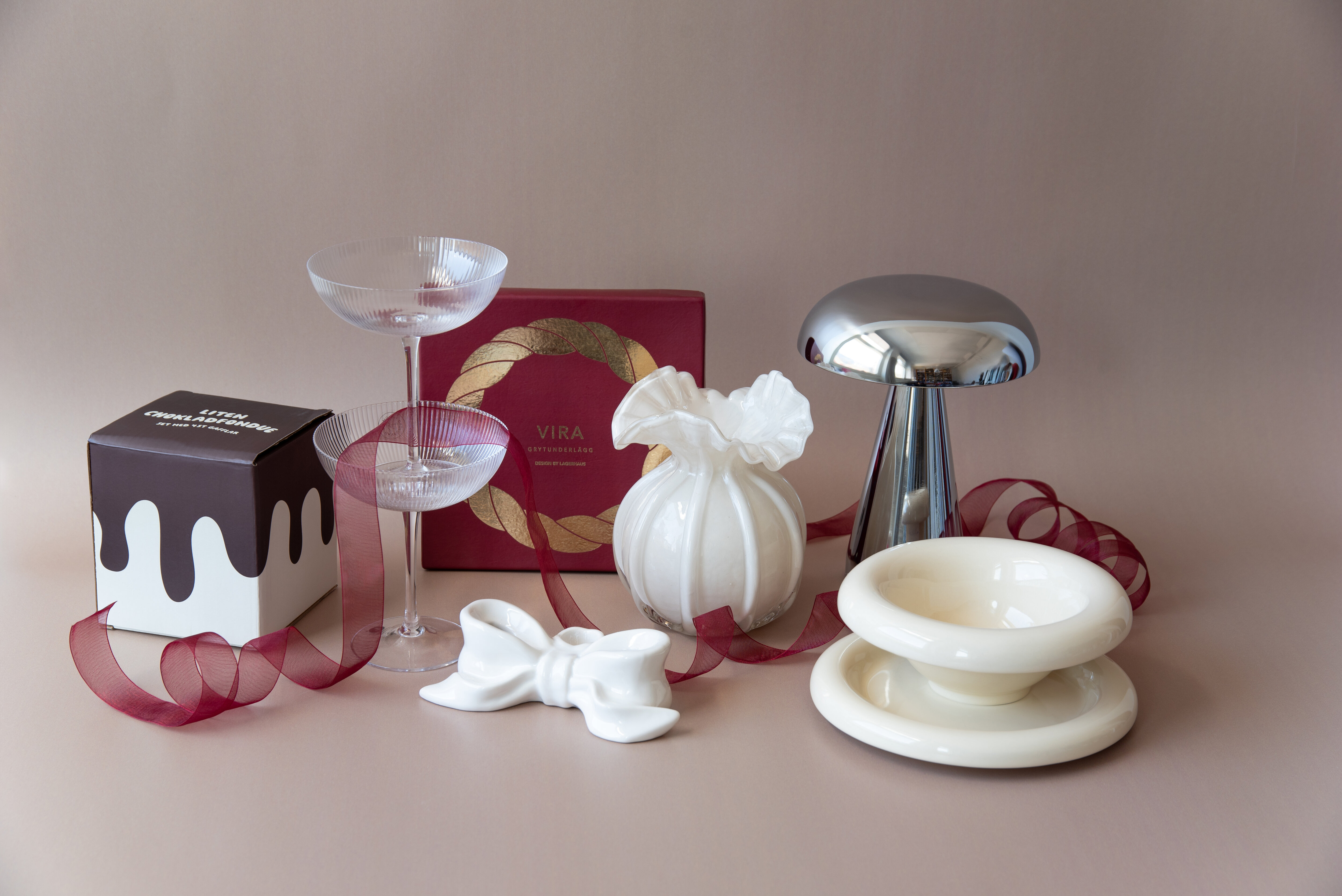 Julinspirerad stilleben med glas, keramik och presentförpackningar.