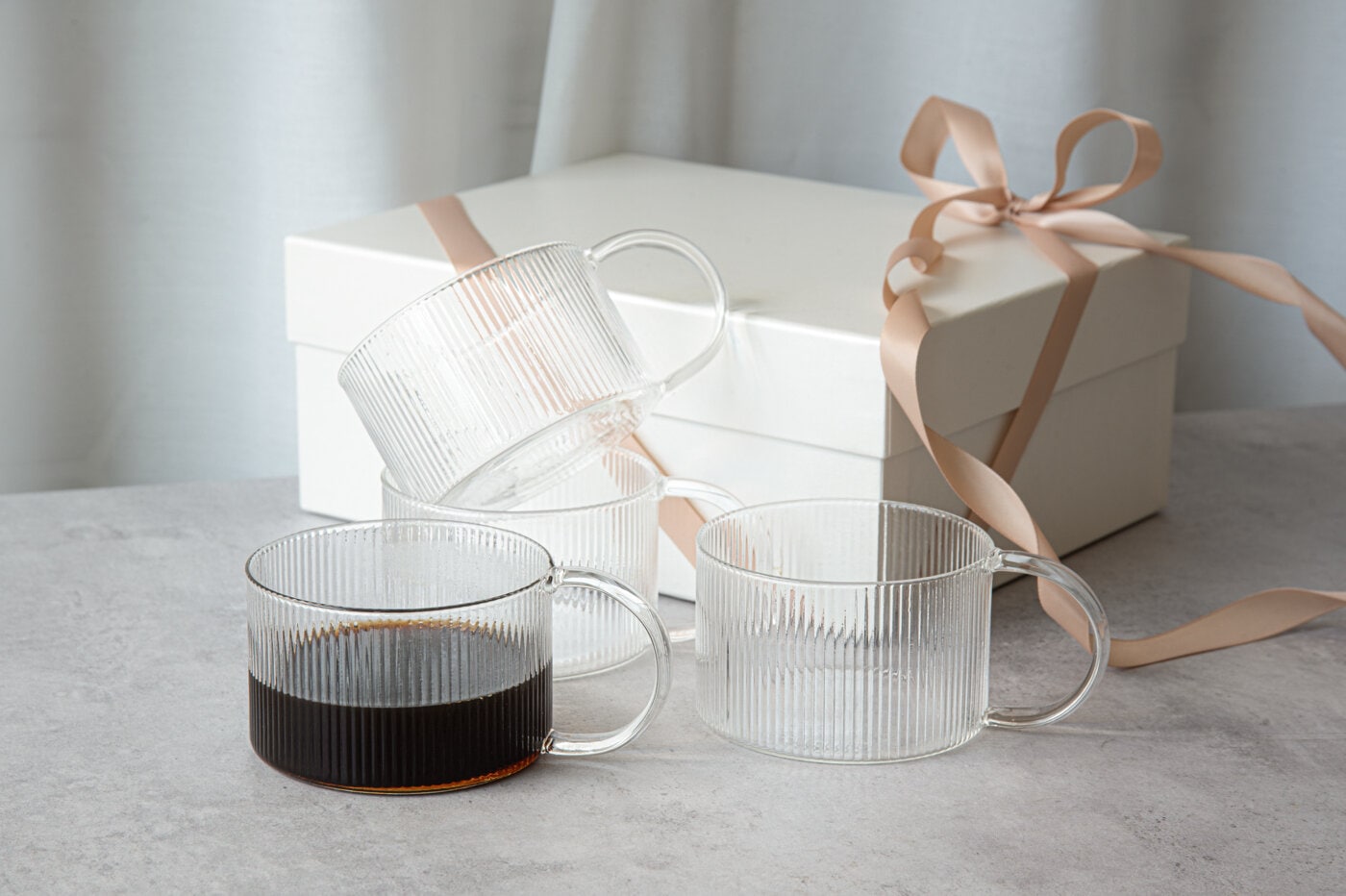 Ribbade muggar i glas med kaffe jämte presentbox.