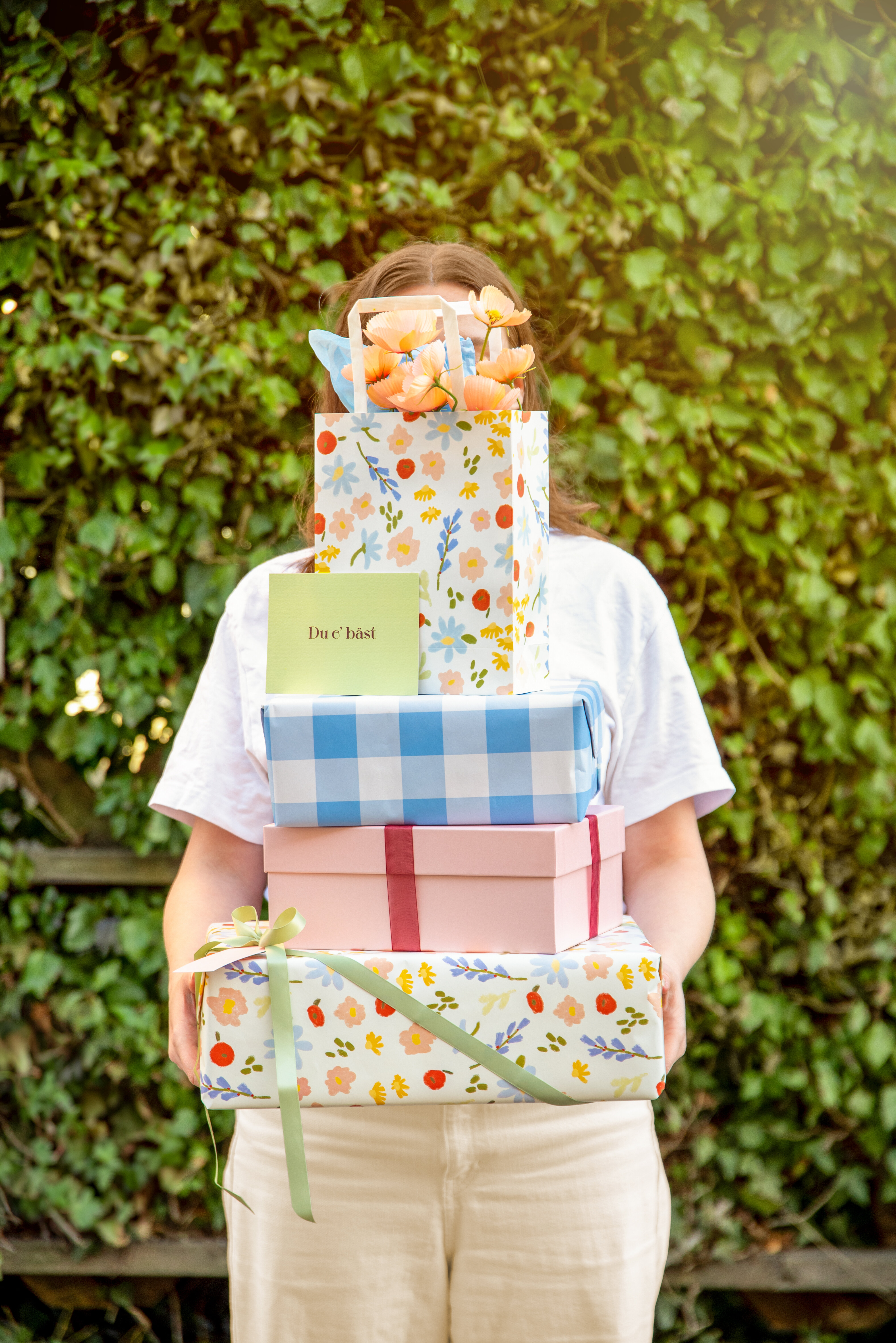 Person som håller i en hög med presenter.