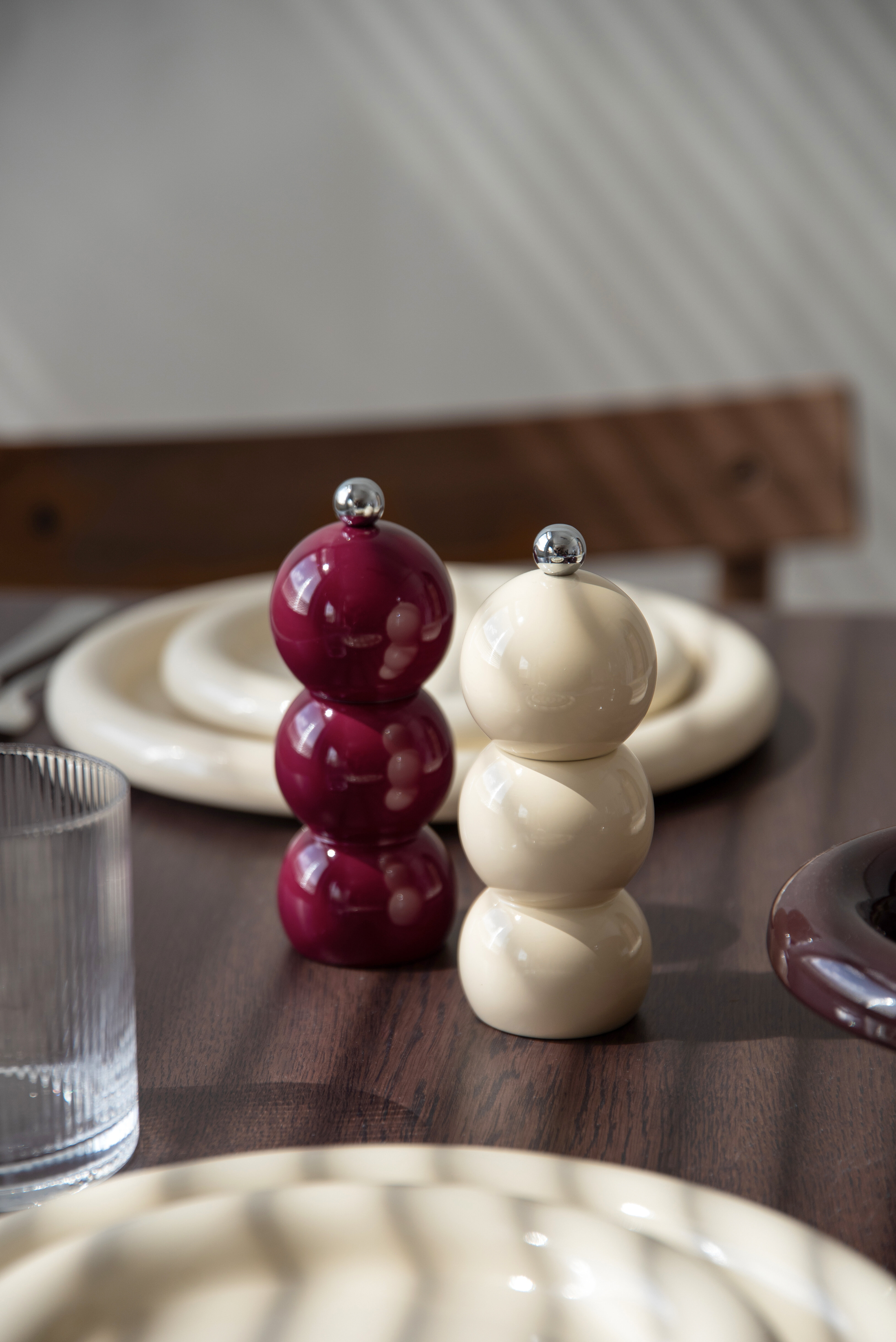Salt- eller pepparkar med runda former på dukat bord.