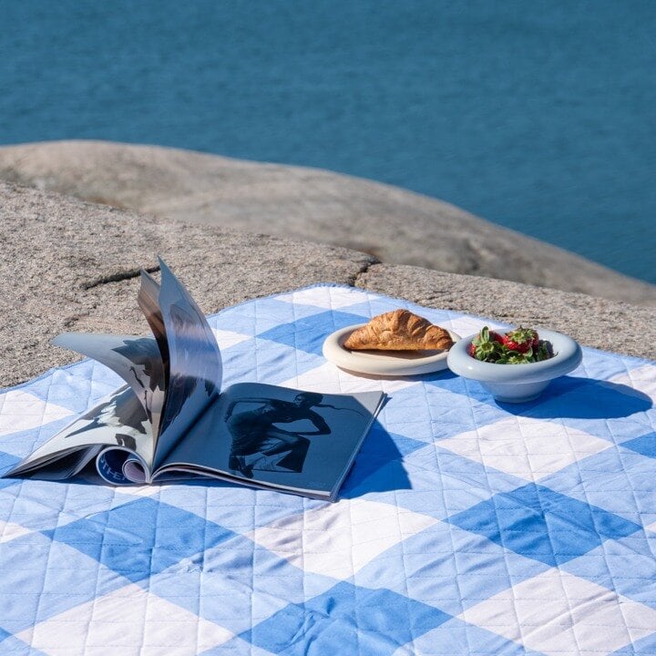 Blå/rutig picknickfilt på ett berg
