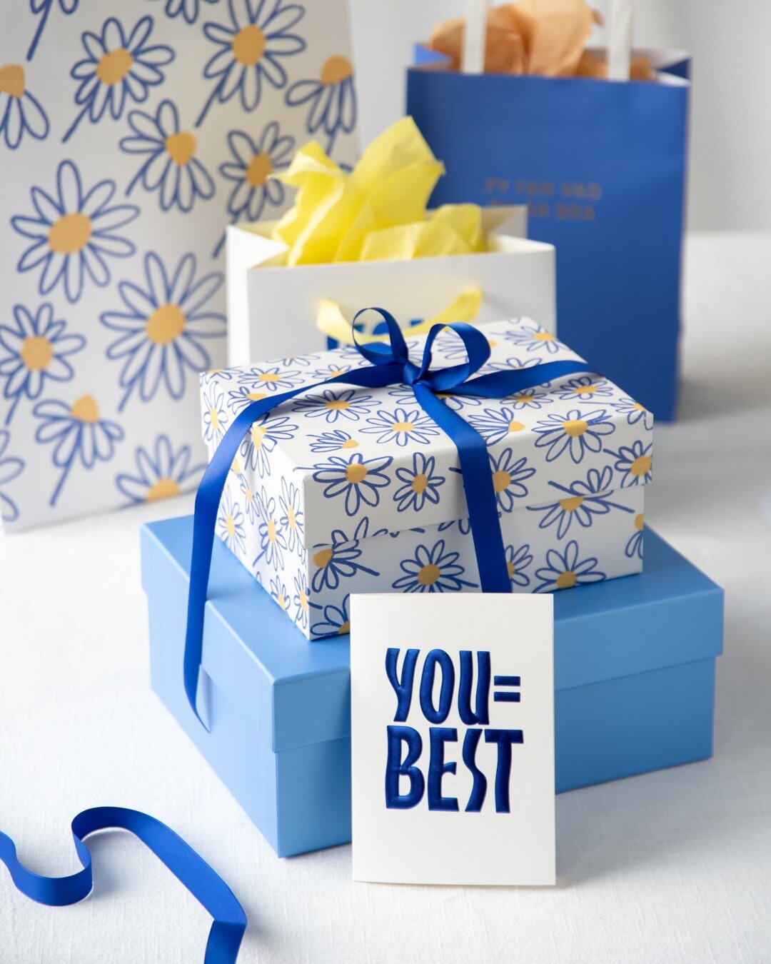 Gåvor inslagna i mönstrat papper med kort och rosetter.