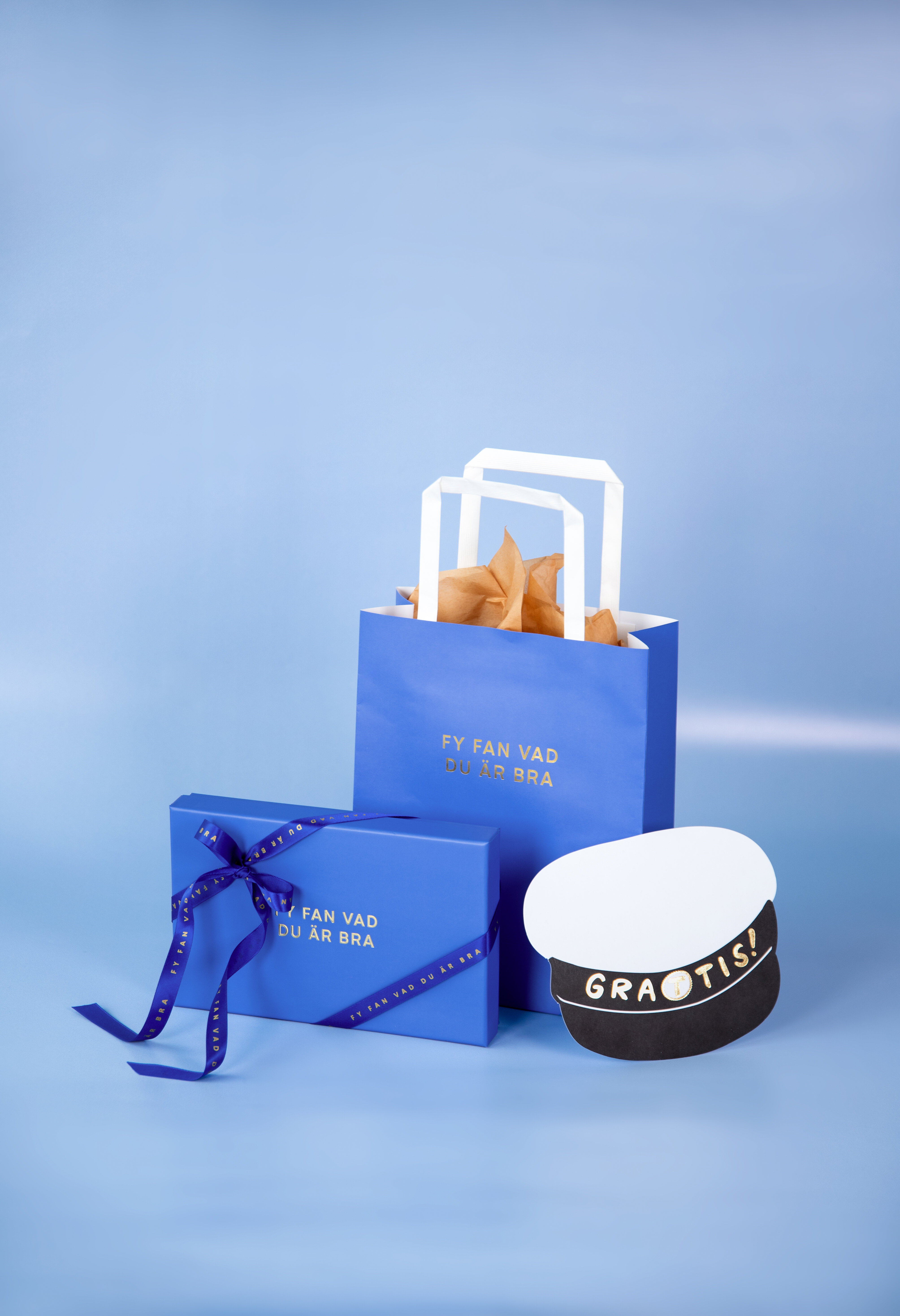Blå presentinslagning och studentpresent på blå bakgrund.